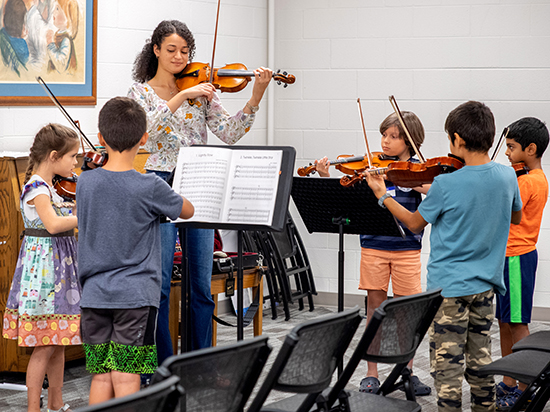 Teacher and children playing violin