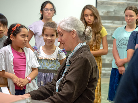Students and teacher at the piano.